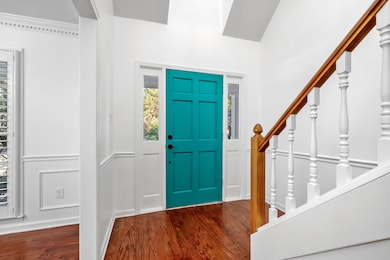 Entryway featuring stairway, dark wood finished floors, and a decorative wall