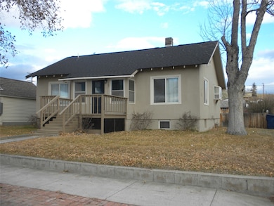Bungalow with a shingled roof, a chimney, a deck, and stucco siding