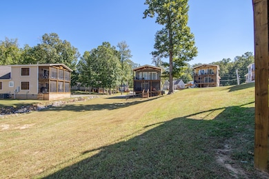View of grassy yard with a balcony