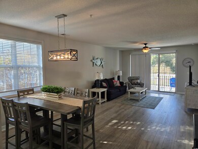 Dining room with a textured ceiling, dark wood-style floors, and a ceiling fan