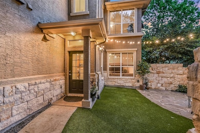Entrance to property with stone siding, a yard, a