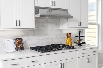 Kitchen with stainless steel gas stovetop, decorat