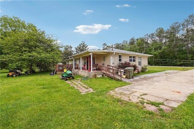 Rear view of house featuring a lawn, a porch, and 