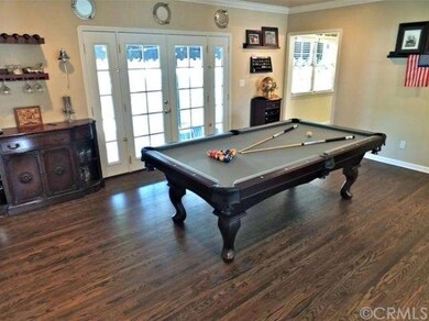 Hardwood flooring in den with French doors to back