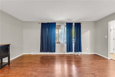 Unfurnished room featuring wood finished floors and baseboards