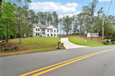 View of front of home with board and batten siding, driveway, and a front yard