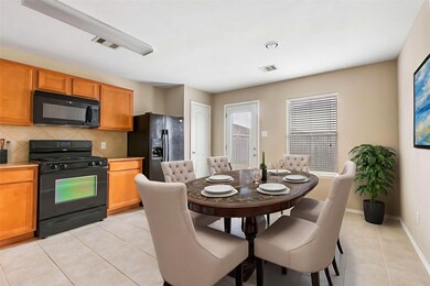 This kitchen and dining area features warm wood ca