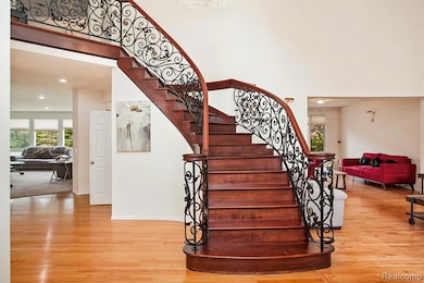 Staircase with wood finished floors and recessed lighting
