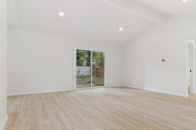 Empty room featuring beamed ceiling, light wood-ty