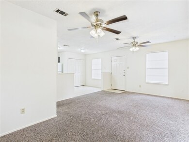 Unfurnished living room featuring light carpet and ceiling fan