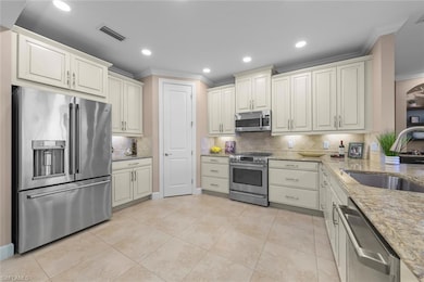 Kitchen with light stone counters, stainless steel