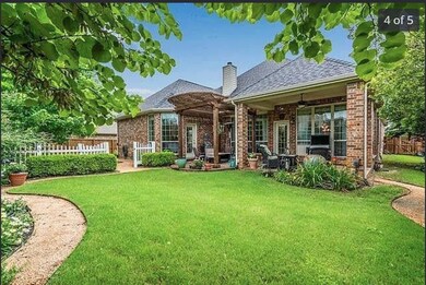 Back of property with brick siding, a patio area, a chimney, a pergola, and roof with shingles