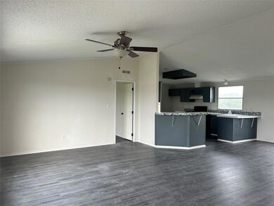 Unfurnished living room featuring a ceiling fan, 
