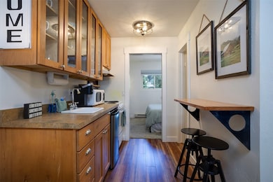 Kitchen with brown cabinetry, dark wood-type floor
