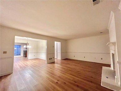 Unfurnished living room featuring LVP finished floors, and a fireplace with raised hearth
