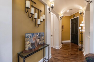 Corridor with ornamental molding and dark hardwood