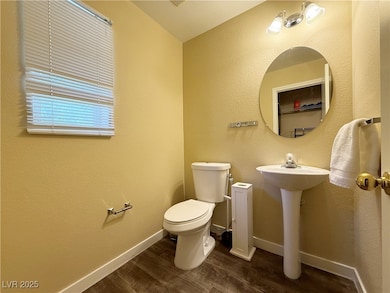 Half bathroom featuring wood finished floors and t