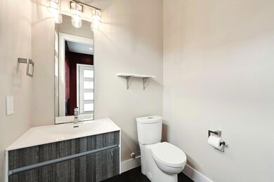 Half bathroom featuring baseboards, vanity, toile