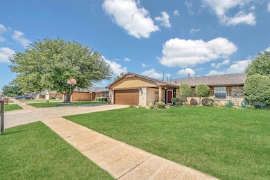 Single story home with a front lawn, driveway, a garage, and brick siding