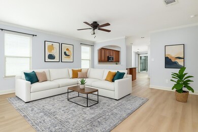 Living room with visible vents, light wood finish