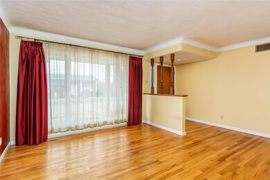 Living room with wood floors and large picture window.