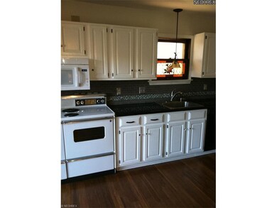 Updated kitchen with hardwood floors, granite counters and glass tile backsplash.