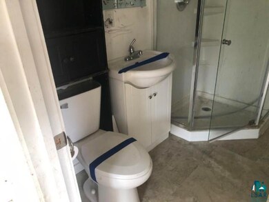 Bathroom featuring vanity, toilet, and a shower wi