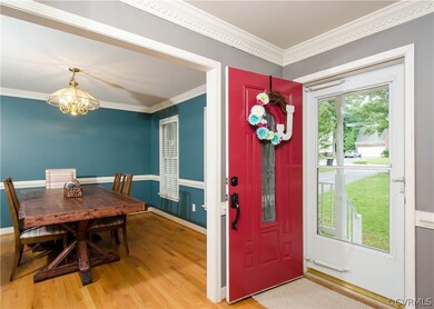 The foyer is welcoming with hardwood flooring, cha