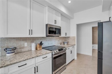 Kitchen with white cabinetry, tasteful backsplash,