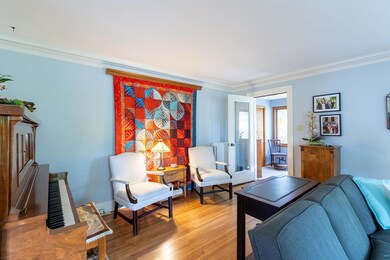 Living area with ornamental molding and wood finished floors