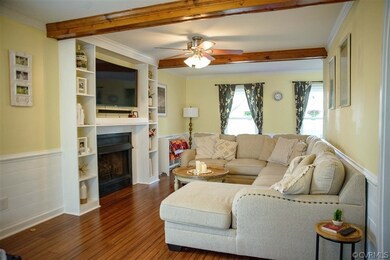 Living room with crown molding, dark wood-type flo