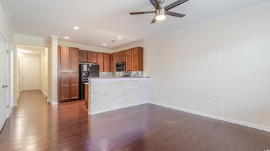 Kitchen featuring black appliances, ceiling fan, dark wood-style floors, backsplash, and ornamental molding