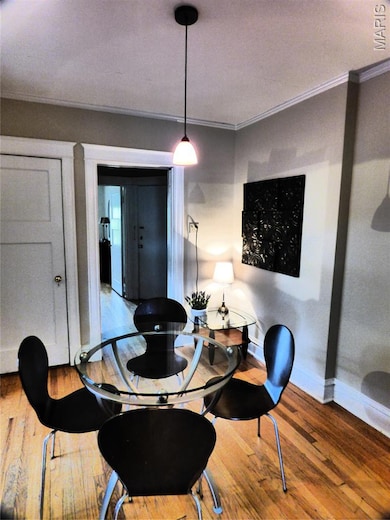Dining room with wood-type flooring and ornamental molding