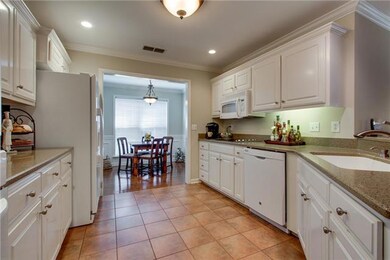 The upgraded kitchen features quartz counter tops, built in cooktop, breakfast bar, beautiful tile flooring and a morning room.