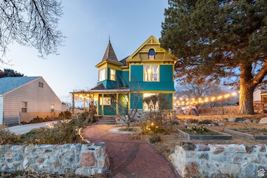Victorian-style house with covered porch and a garden