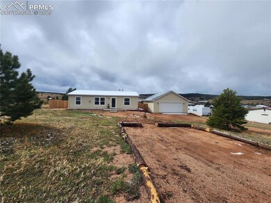 View of front of house featuring fence, an outdoor structure, and a garage