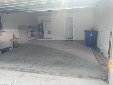 Garage featuring concrete block wall and water hea
