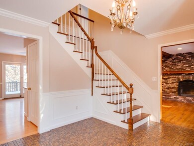 Light filled foyer with grand staircase.