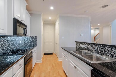 Kitchen featuring white cabinetry, sink, ornamenta