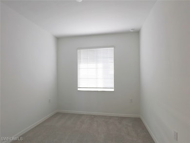 Empty room with light carpet and baseboards