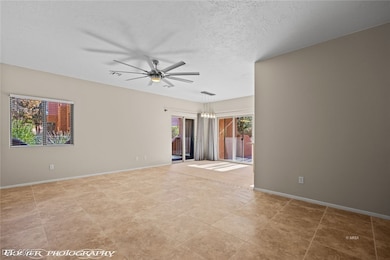 Empty room with a textured ceiling, visible vents,