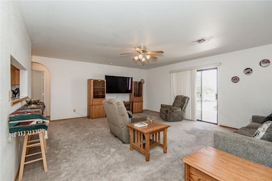 Living area featuring a ceiling fan, light colored