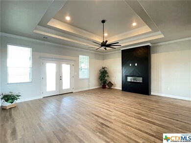 Voluminous living room boasts LVP flooring, tiered