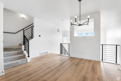 Unfurnished dining area with light wood-style floors, a chandelier, and stairway