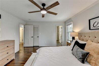 Bedroom featuring crown molding, dark wood finished floors, connected bathroom, and a ceiling fan