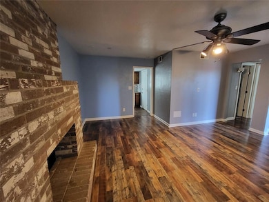 Unfurnished living room with dark wood finished floors and ceiling fan