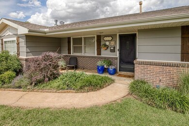 Entrance to property featuring brick siding, a porch, and roof with shingles