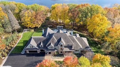 Nestled on a private wooded lakeshore lot, this 2007-built home offers luxurious living with six bedrooms and seven bathrooms across 8,504 finished square feet.