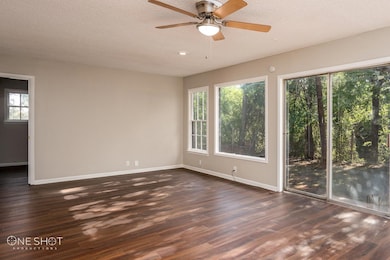 Unfurnished room featuring ceiling fan, dark wood-