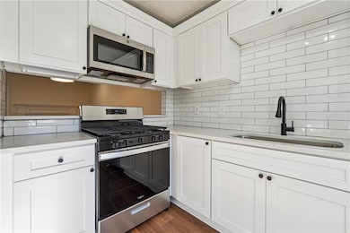 Kitchen with stainless steel appliances, backsplas